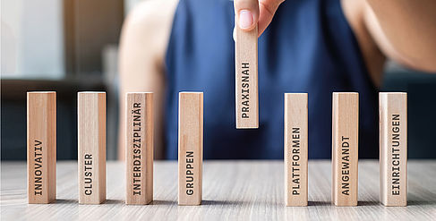Vertical wooden rods on which stands innovative, practical, applied © iStock, Panuwat Dangsungnoen, Montage: Juliane Strehmann Vertical wooden rods on which stands innovative, practical, applied